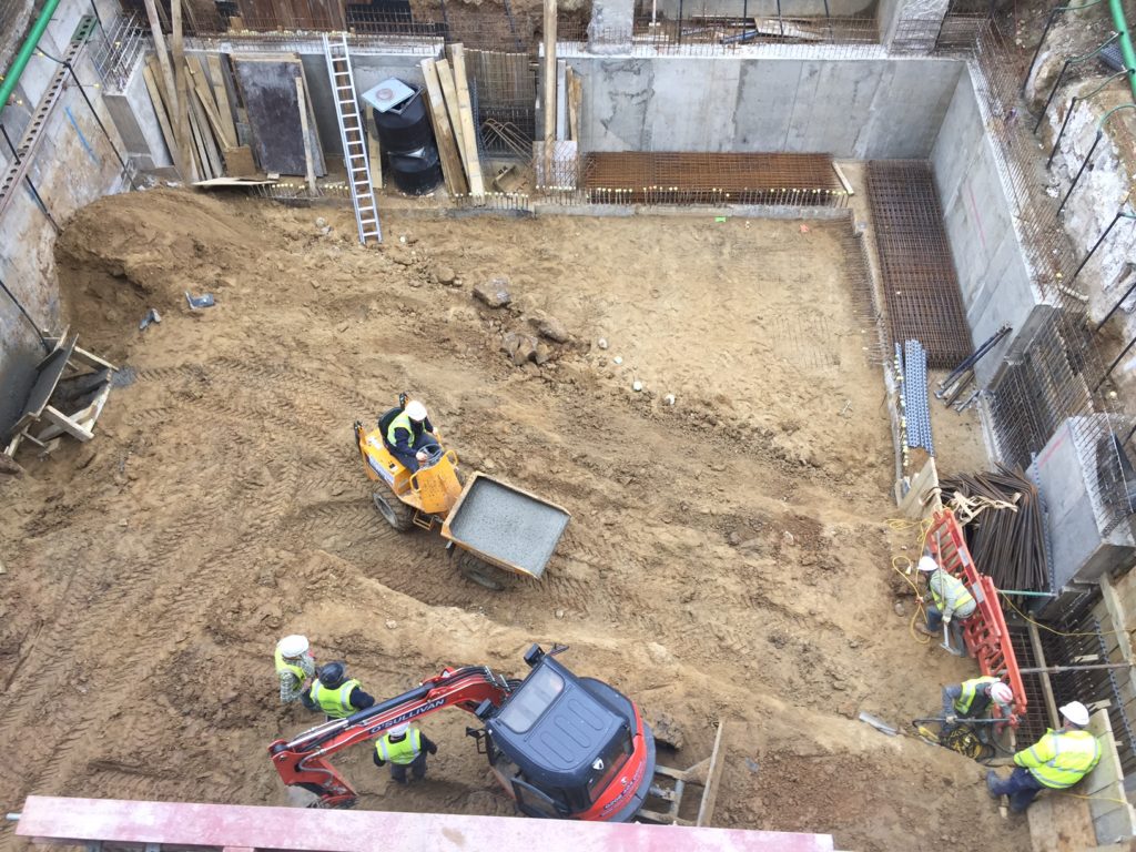 An O'Sullivan mini excavator at work on the early excavation phase, working carefully adjacent to the existing Victorian terrace at Holland Villas Road.