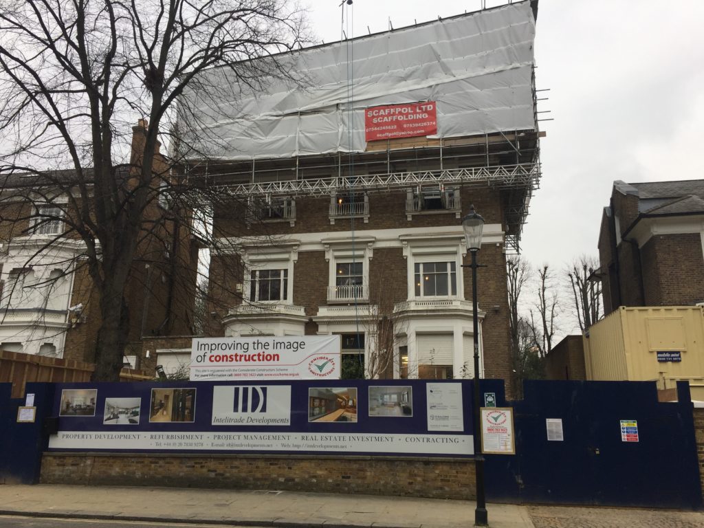 The front elevation of the property secured with scaffolding and site hoardings during the basement construction works at Holland Villas Road, west London.
